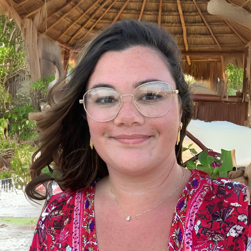 Smiling woman with short blonde hair and friendly brown eyes wearing a flowered blouse complementing her natural aesthetic and inviting expression.